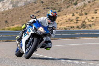 Asfaltta yatan bir motosikletli. Fotoğraf 26 Ekim 2020 'de Avila, Spai' deki Navalmoral limanında çekildi.