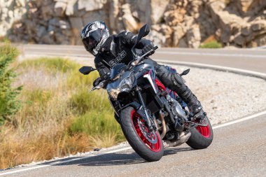 Asfaltta yatan bir motosikletli. Fotoğraf 26 Ekim 2020 'de Avila, Spai' deki Navalmoral limanında çekildi.