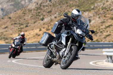 Asfaltta yatan bir motosikletli. Fotoğraf 26 Ekim 2020 'de Avila, Spai' deki Navalmoral limanında çekildi.