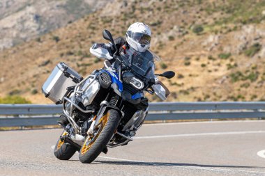 Asfaltta yatan bir motosikletli. Fotoğraf 26 Ekim 2020 'de Avila, Spai' deki Navalmoral limanında çekildi.