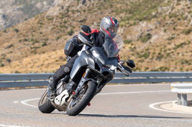 Asfaltta yatan bir motosikletli. Fotoğraf 26 Ekim 2020 'de Avila, Spai' deki Navalmoral limanında çekildi.