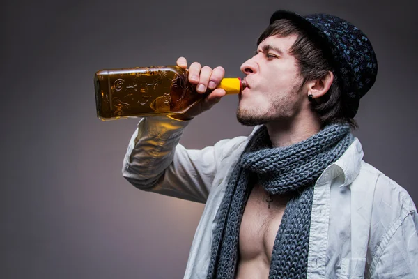 Moderiktiga killen i en hatt dricka tequila — Stockfoto