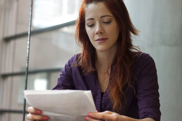 Empresaria leyendo documentos financieros - sonriendo Fotos de stock libres de derechos