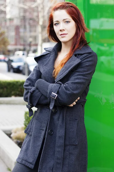 Businesswoman standing downtown leaning against reflective wall — Stock Photo, Image