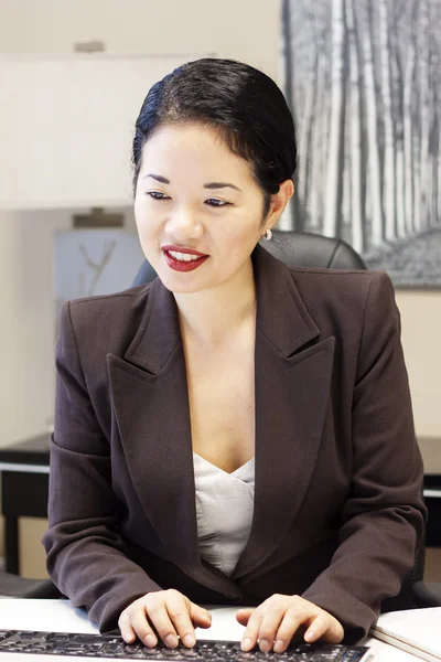 Bastante asiático mujer de negocios escribiendo y sonriendo Fotos de stock libres de derechos