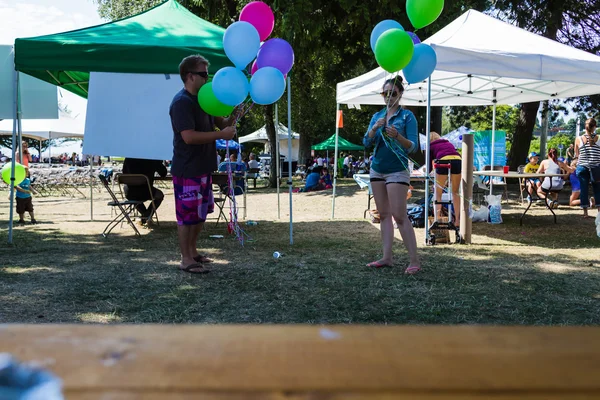 Blowing up balloons at harmony arts festival — Stock Photo, Image