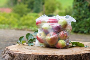 Plastik bir torbaya doldurulmuş kırmızı elmalar.