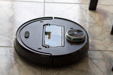 Robot elektrik süpürgesi bir apartmanın zeminini temizliyor.