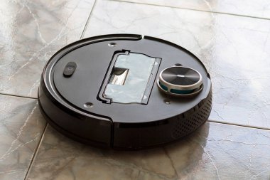 Robot elektrik süpürgesi bir apartmanın zeminini temizliyor.