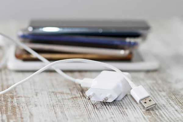 A smartphone battery and its charging and audio cables