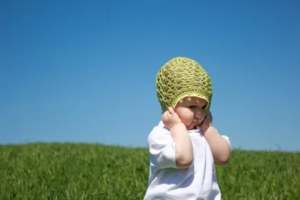 Маленькая девочка стоит на зеленой траве — стоковое фото
