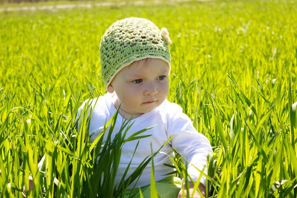 Little girl sitting on the grass — Stock Photo, Image