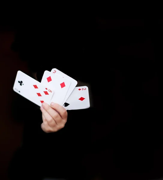Händerna håller spelkort Stockbild