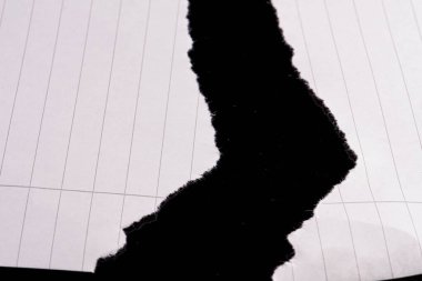 Torn lined white sheet on black