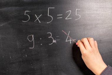 Çocuk bir tahtanın üzerine yazıp hesaplıyor.