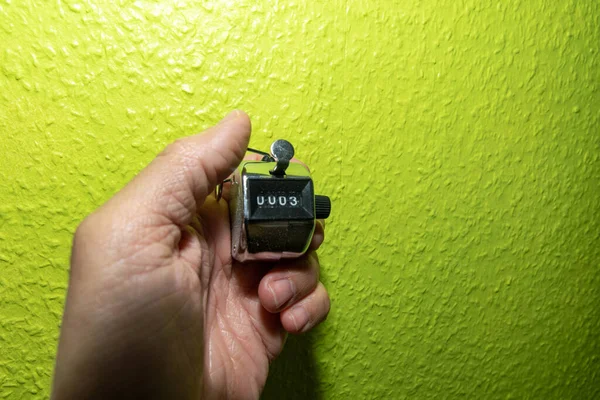 在绿墙前手拿着计时器 — 图库照片