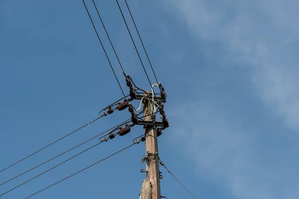 Above-ground electricity pylon against a blue sky