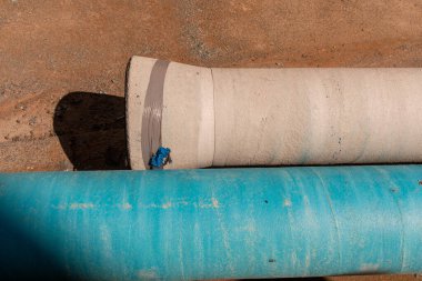 Bir şantiyede su ve benzin için iki boru.