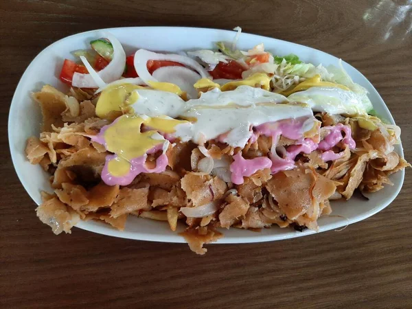 Vegan kebab plate with seitan and different coloured sauces