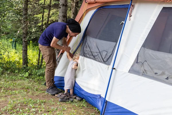 Father and son explore camping tent