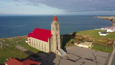 Saint Simon ve Saint Jude Kilisesi 'nin Gloucester County, New Brunswick, Kanada' daki Caraquet sahilinde kırmızı çatılı insansız hava aracı görüntüleri..
