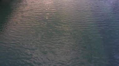 Yavaş çekim drone görüntüleri Saint Lawrence Nehri 'nde sakin dalgalanmalar gösteriyor. Kamera eski limana ve Montreal, Quebec, Kanada şehrine doğru dönüyor..