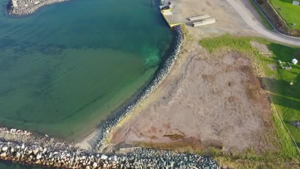 加拿大新不伦瑞克Caraquet海岸线上美丽的航拍镜头 背景为天主教教堂及坟场的小渔港 — 图库视频影像