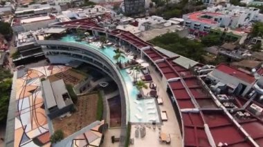 Thompson Playa del Carmen turizm merkezinin yukarısında, Quintana Roo, Meksika 'da büyük bir çatıda yüzen insanların olduğu kısa insansız hava aracı klibi..