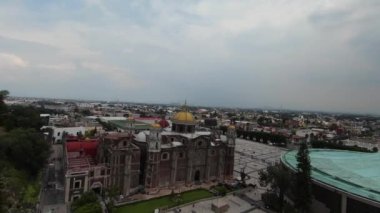 Aerial footage of the Catholic Church of Our Lady of Guadalupe with gold dome and modern basilica on the right. National shrine site in Mexico City.