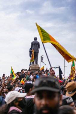 COLOMBO, SRI LANKA: 9th July 2022: Selective focus shot of a mass street protest with people waving national flags by the Presidential Secretariat HQ.