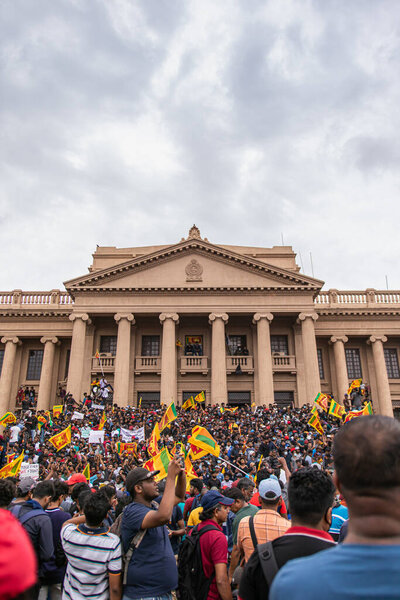 COLOMBO, SRI LANKA: 9 июля 2022: Толпа людей объединяется у колониального фасада здания секретариата президента во время протестов.