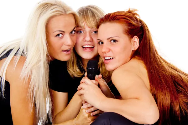 Three beautiful girls sing into the microphone — Stock Photo, Image