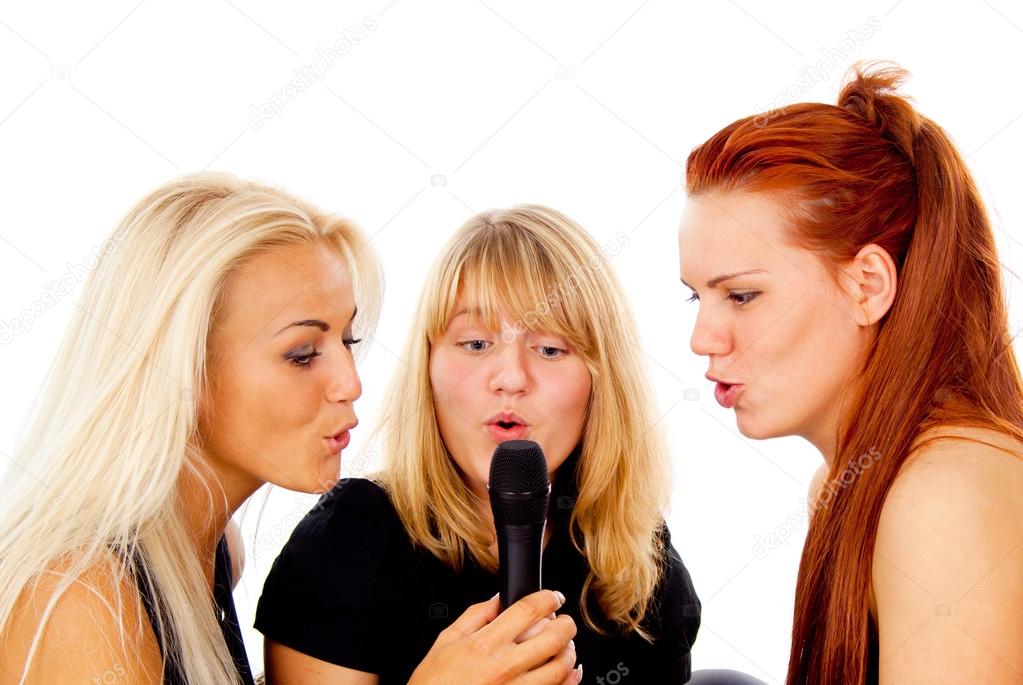 Three beautiful girls sing into the microphone