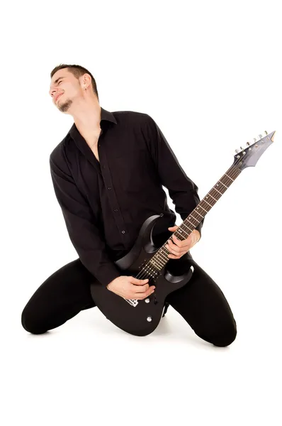 O jovem bonito senta-se e toca guitarra elétrica — Fotografia de Stock