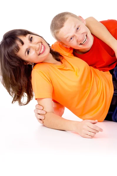 Gelukkig meisje ligt op zijn rug op de kerel op de verdieping — Stockfoto