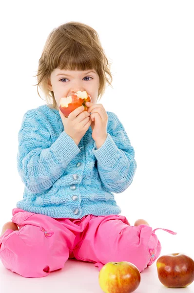 A beautiful little, girl eats apples — Stockfoto