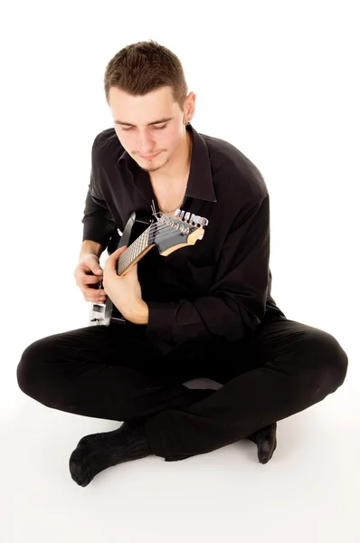 Hermoso chico está tocando la guitarra eléctrica, sentado en el flo —  Fotos de Stock