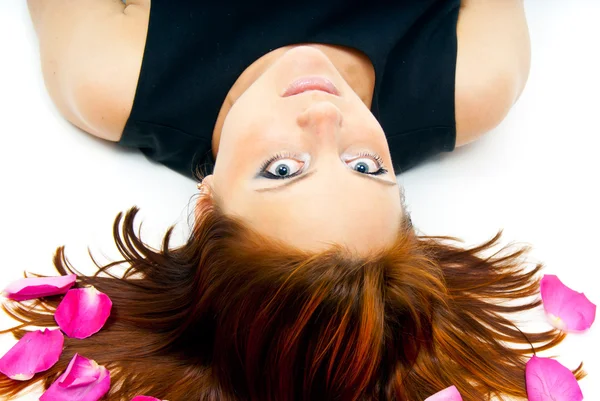 Girl lying on a background of rose petals — Stock Photo, Image