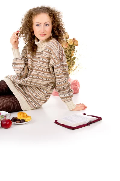 Girl sits in a sweater and a book and resting — Stock Photo, Image
