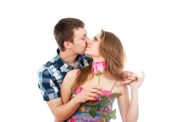 Chico besa a una chica con una rosa — Foto de Stock