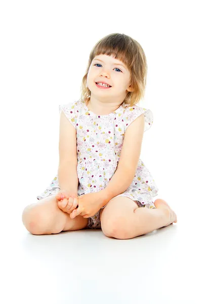 Счастливая маленькая девочка сидит — стоковое фото