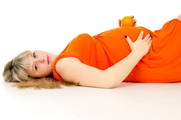 Mujer embarazada feliz acostada con naranjas — Foto de Stock