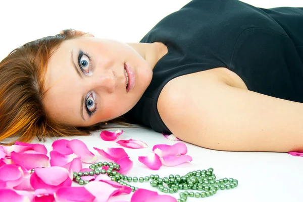 Retrato de uma menina deitada em pétalas de rosa — Fotografia de Stock