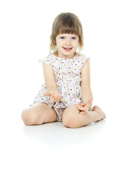 Sits a beautiful little girl in a dress — Stock Photo, Image