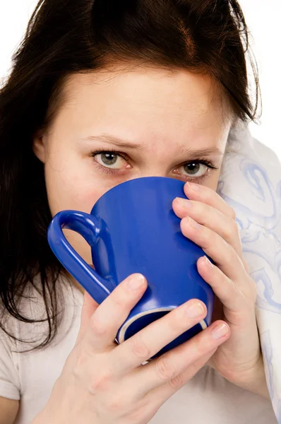 Das kranke schöne Mädchen liegt auf dem Bett und trinkt Medizin — Stockfoto