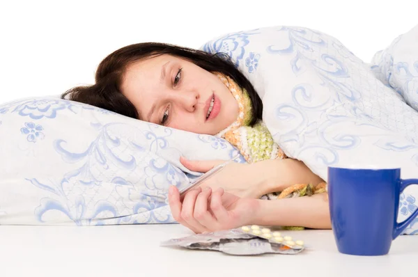 De zieke meisje liggend in bed, het drinken van thee — Stockfoto