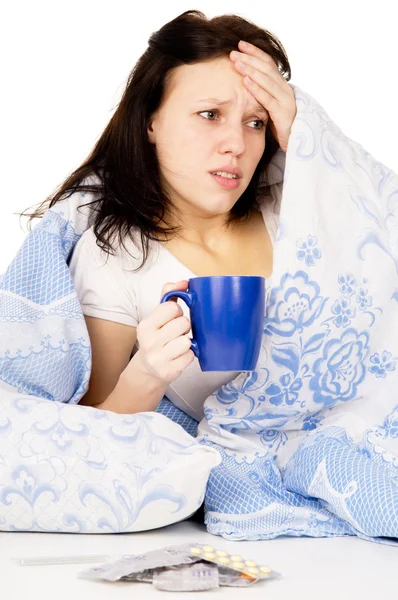 A menina doente deitada na cama, e beber remédio — Fotografia de Stock