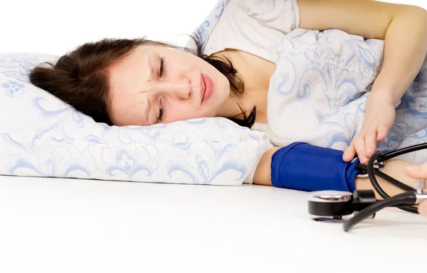 La fille malade couchée sur le lit, et mesurer la pression — Photo