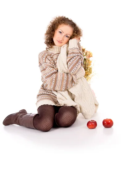 Krásná dívka v svetr sedí s jablky — Stock fotografie