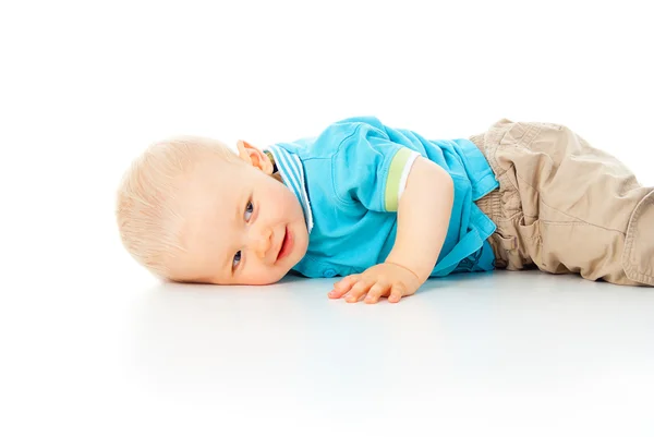 Criança encontra-se no chão branco — Fotografia de Stock